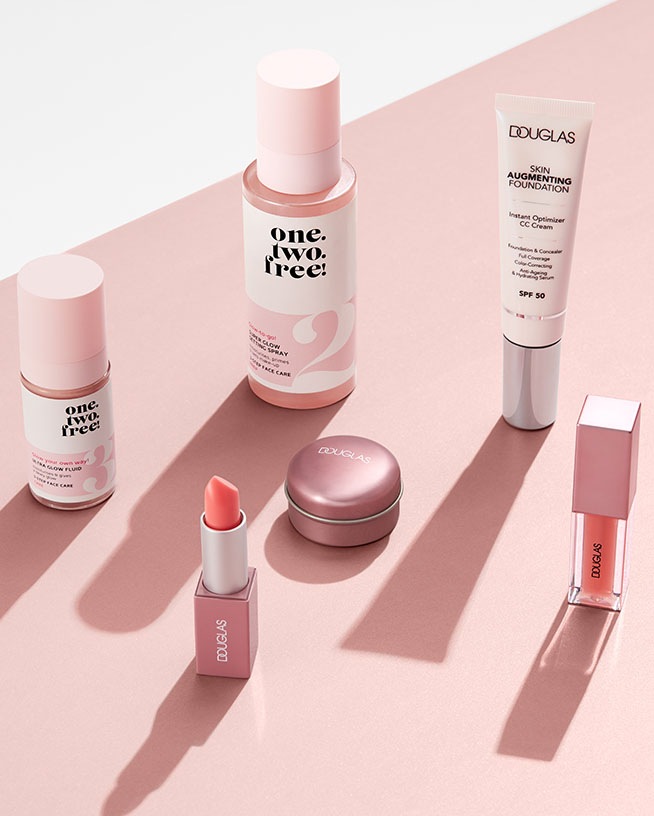Ontdek de Douglas collectie met huidversterkende foundation, CC cream, lippenstift en glow fluid, allemaal in zachte, roze tinten.