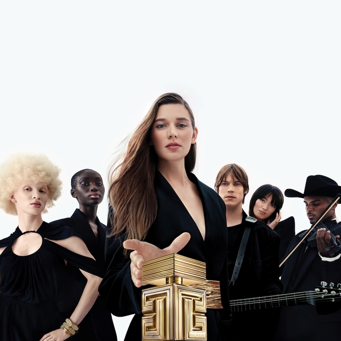 Een groep diverse modellen, gekleed in zwarte outfits, poseert met een gouden Balmain-parfumflesje op de voorgrond, wat de luxe en elegantie van het merk benadrukt.