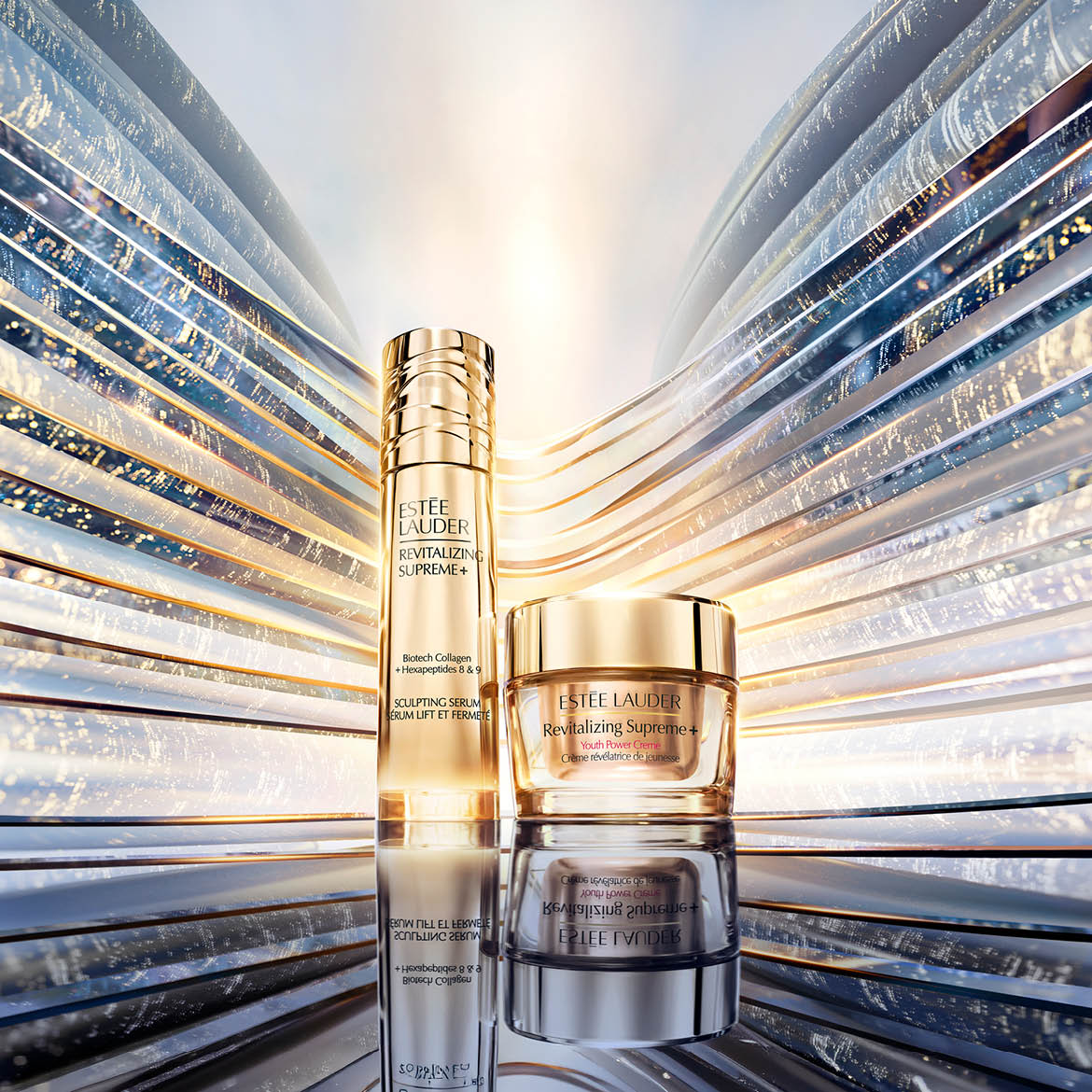 De Estée Lauder Revitalizing Supreme+ Sculpting Serum en Youth Power Crème, verrijkt met Biotech Collageen en Hexapeptiden 8 & 9, staan elegant op een spiegelend oppervlak tegen een futuristische achtergrond van glanzende, golvende panelen.