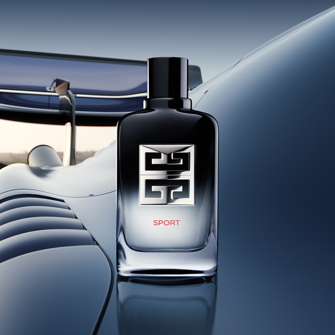 Strakke, heldere glazen flacon Givenchy Sport eau de toilette met zwarte dop en zilverkleurig logo, geplaatst voor een gestroomlijnde blauwe auto.