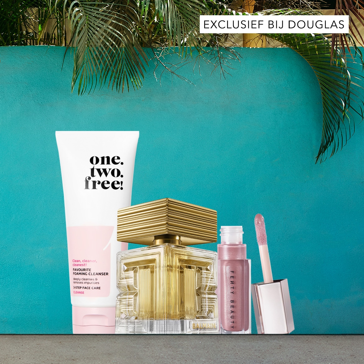 Ontdek de "one. two. free!" FAVOURITE FOAMING CLEANSER, een witte tube met roze accenten die diep reinigt en onzuiverheden verwijdert, exclusief verkrijgbaar bij Douglas, samen met een gouden parfumfles en een roze Fenty Beauty lipgloss.