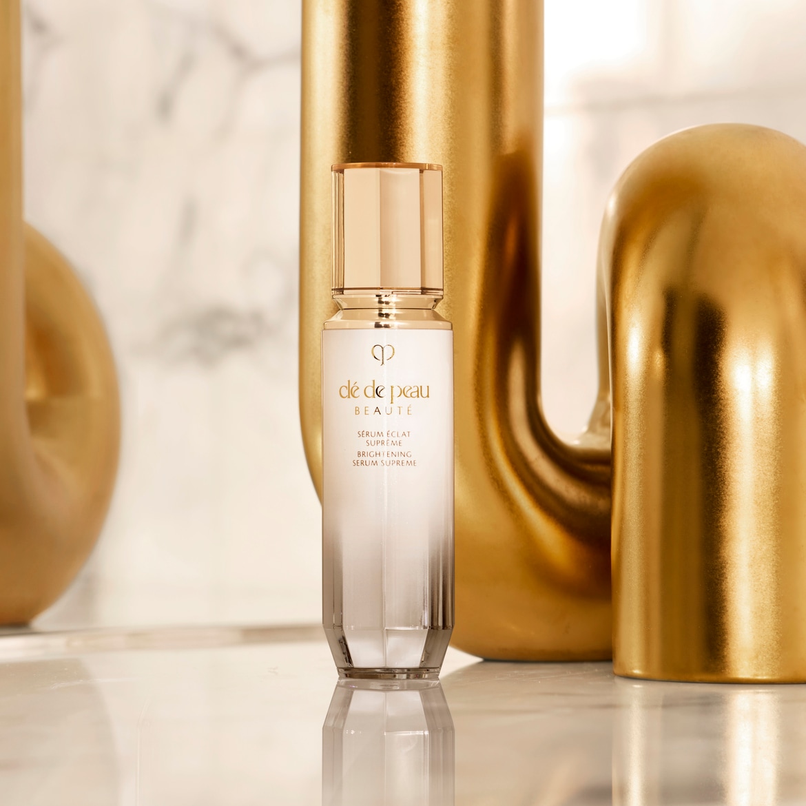 Ontdek de Clé de Peau Beauté Sérum Éclat Suprême, een helder serum in een elegante witte flacon met gouden accenten, dat zorgt voor een stralende en egale teint.
