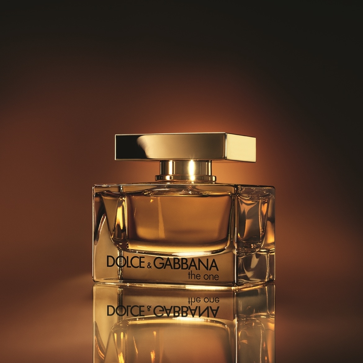 Gouden vierkante flacon van Dolce & Gabbana The One parfum, met een gouden dop en het logo in zwarte letters.