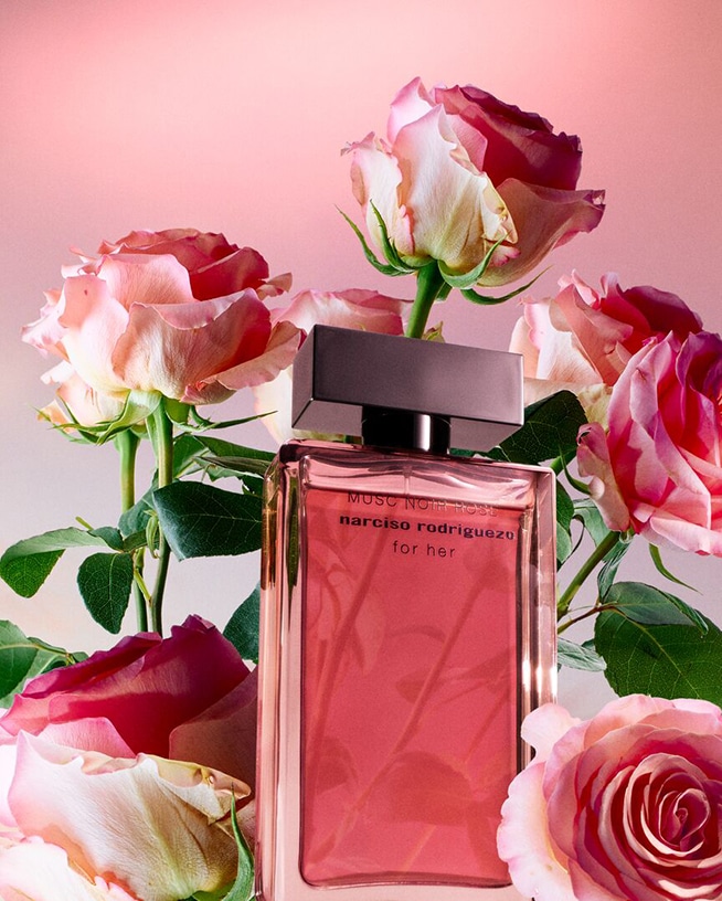 De Narciso Rodriguez Musc Noir Rose for her Eau de Parfum, gehuld in een heldere fles, omringd door roze rozen, straalt een bloemige en sensuele geur uit.