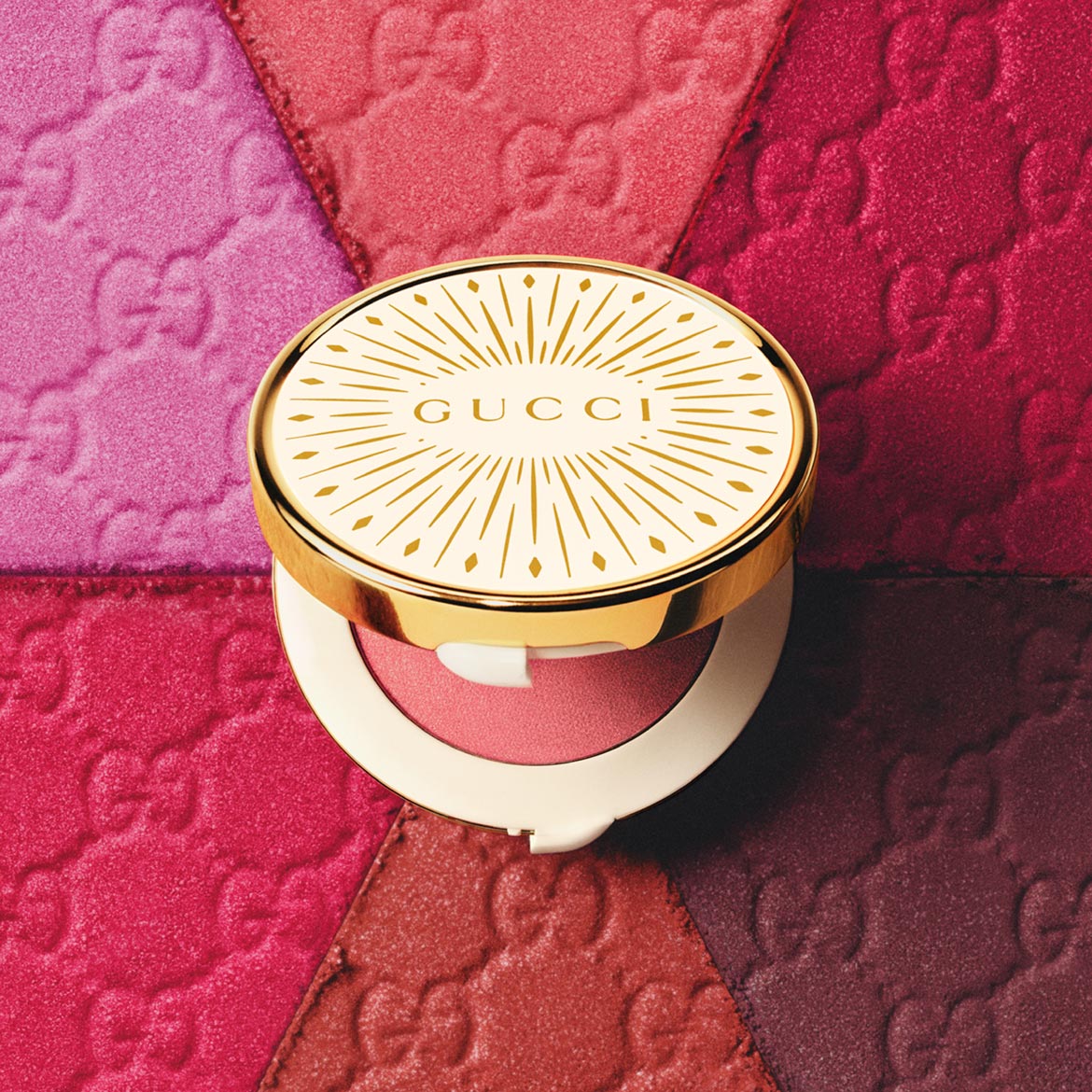 Ontdek de Gucci blush met een gouden verpakking, geplaatst op een achtergrond van verschillende tinten roze blush, voor een stralende teint.