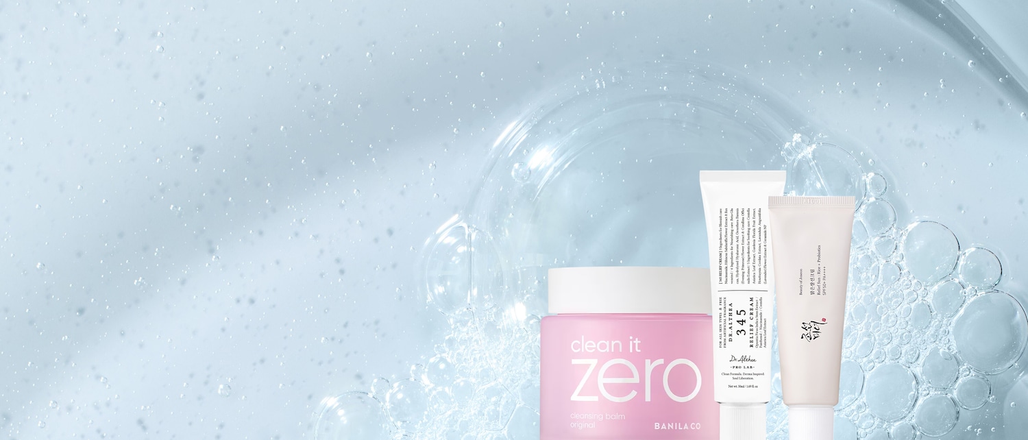 Op een blauwe achtergrond met bubbels staan een roze pot Clean it Zero cleansing balm, een witte tube Dr. Althea 345 Relief Cream en een witte tube Beauty of Joseon Relief Sun: Rice + Probiotics.