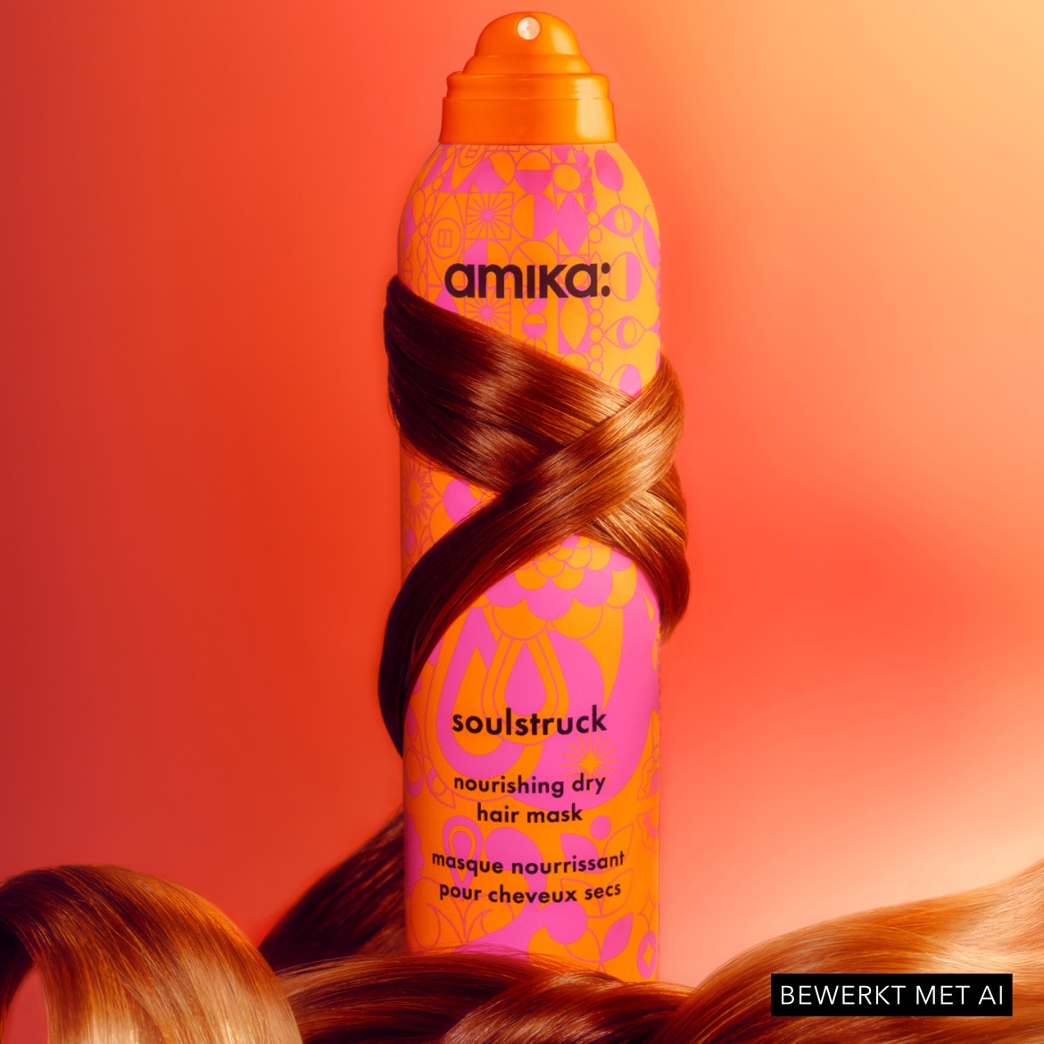 De Amika Soulstruck Nourishing Dry Hair Mask in een oranje spuitbus met roze en gele bloemmotieven, omwikkeld met glanzend bruin haar, staat tegen een levendige oranje achtergrond.