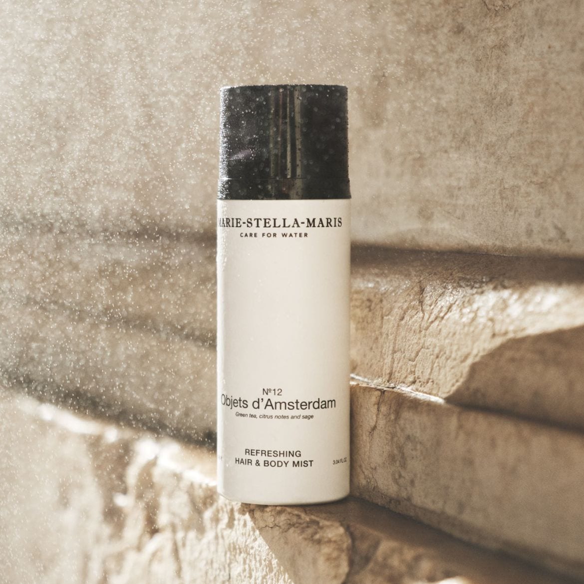 De Marie-Stella-Maris Objets d'Amsterdam No. 12 verfrissende haar- en bodymist met groene thee, citrus en salie in een witte flacon met zwarte dop.