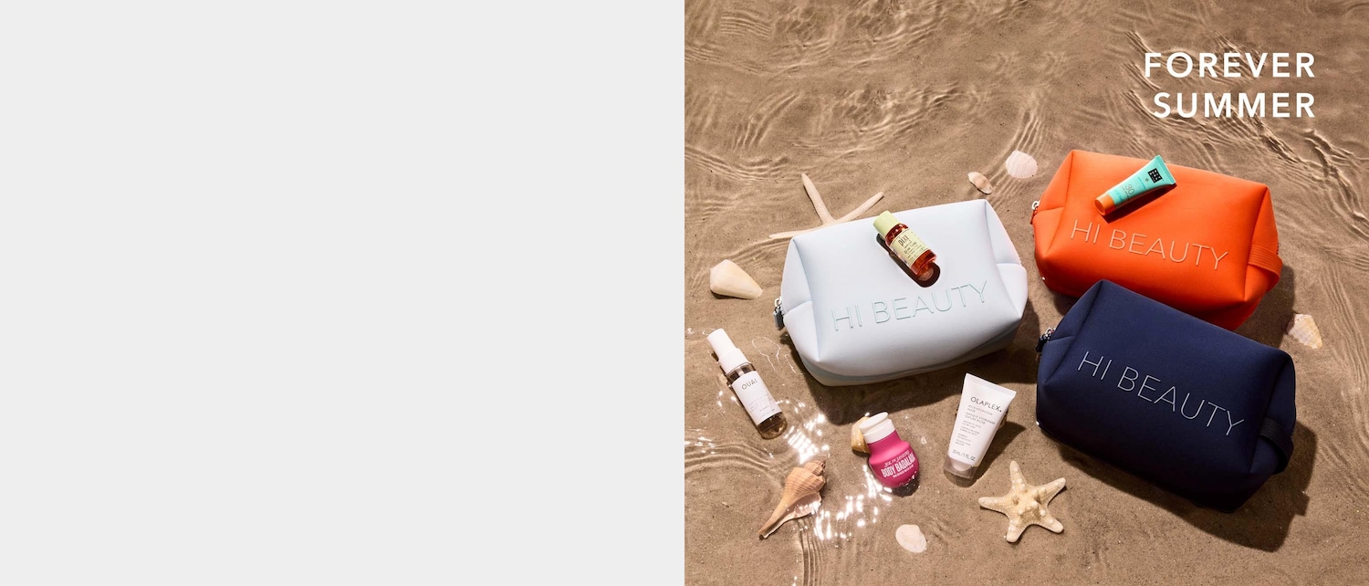Drie 'HI BEAUTY' toilettassen in lichtblauw, oranje en donkerblauw liggen op nat zand met schelpen en zeesterren, omringd door diverse beautyproducten.